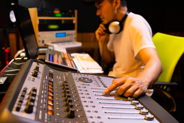 asian male professional sound engineer working in recording, broadcasting, editing studio