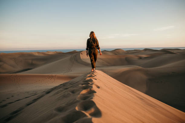 istock Aviator woman walking on dune 1150769978