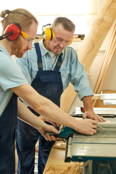 istock Two Carpenters Cutting Wood 1150770133
