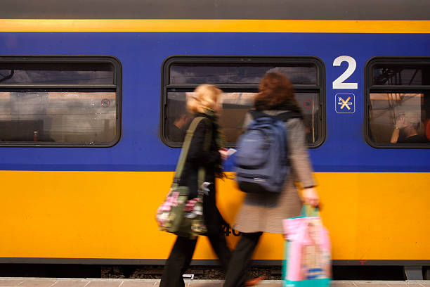 woman running to fetch the train after shopping - trein nederland stockfoto's en -beelden