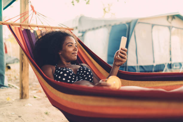 donna rilassata sull'amaca - summer vacations women hammock foto e immagini stock