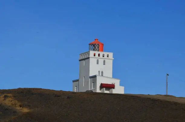 Red lantern on a white tower in Vik Iceland.