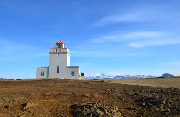 Beautiful snow capped mountains behind Dyrholaey Lighthouse in Iceland.
