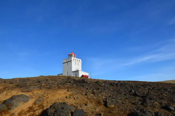 Vik Iceland's Dyrholaey Lighthouse against a blue sky.