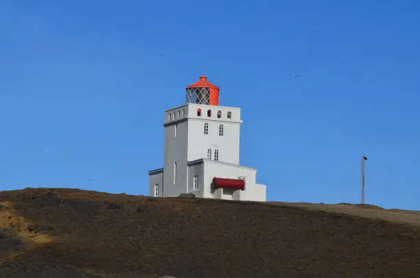 Iceland's red and white Dryholaey Lighthouse in Vik Iceland.