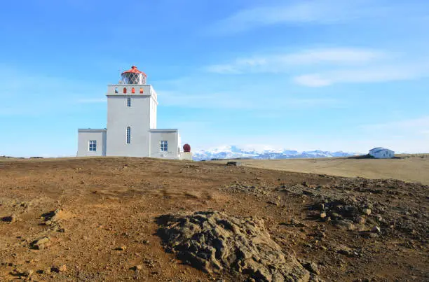 Snow on the mountains behind Dyrholaey Lighthouse in Vik Iceland.