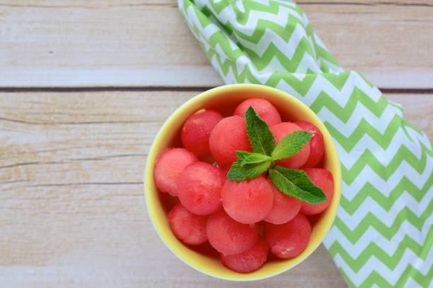 Frische Wassermelonenkugeln auf Dessertschale garnieren mit Minzblatt – Foto