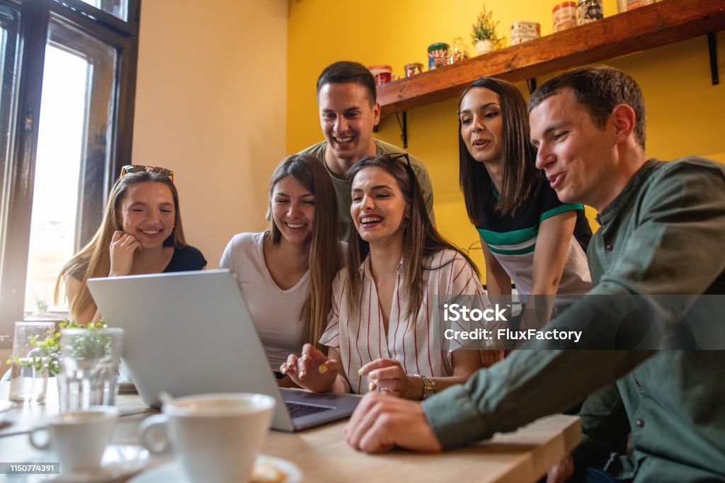 Group Of Joyful Friends Watching Funny Videos Online While Waiting On The  Waiter To Come Stock Photo - Download Image Now - iStock