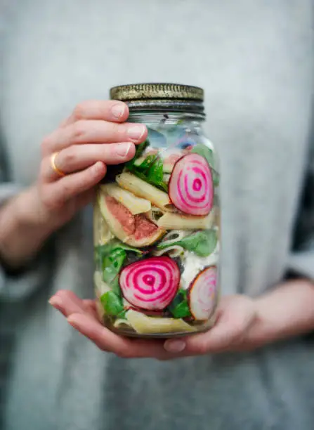 A fresh garden salad in a jar with figs, goats cheese and beetroot.