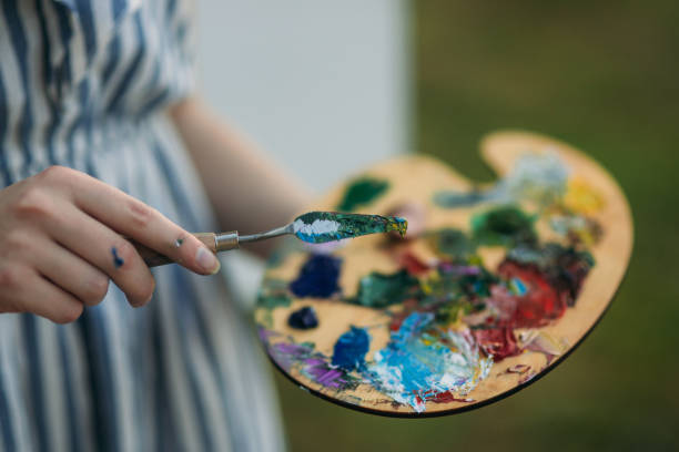 istock Girl is holding Palette with paints and spatula 1150776583