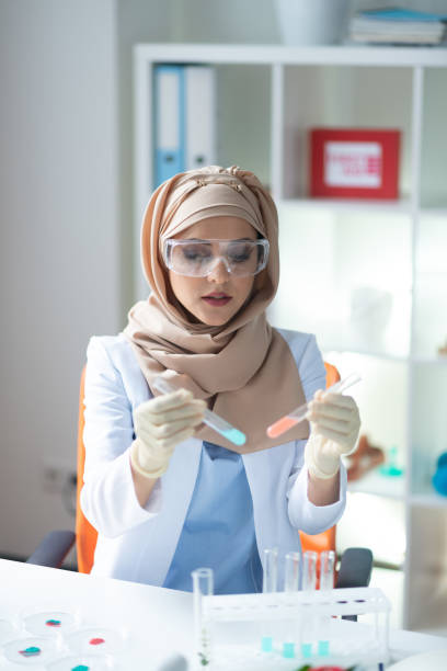 istock Female chemist wearing hijab feeling busy analyzing chemicals 1150778443