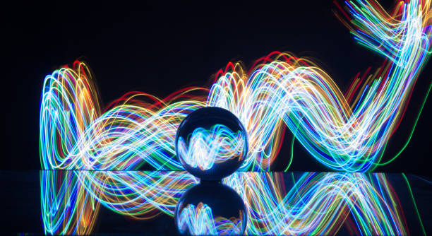 istock Light painting with crystal ball using led Christmas colorful lights and light reflection on glass with selective focus 1150779248