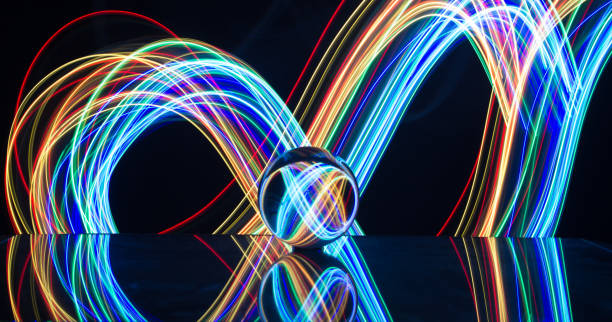 istock Light painting with crystal ball using led Christmas colorful lights and light reflection on glass with selective focus 1150779294
