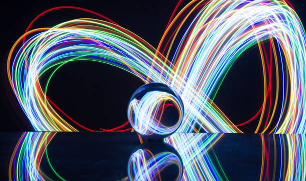 istock Light painting with crystal ball using led Christmas colorful lights and light reflection on glass with selective focus 1150779310