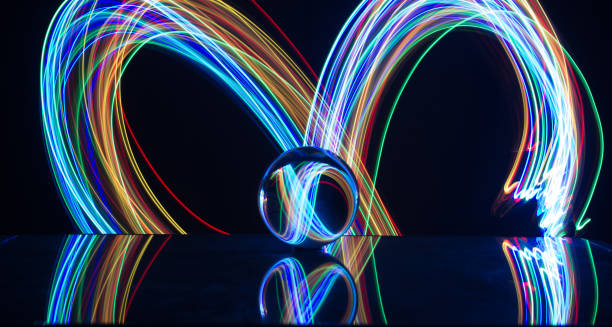 istock Light painting with crystal ball using led Christmas colorful lights and light reflection on glass with selective focus 1150779331