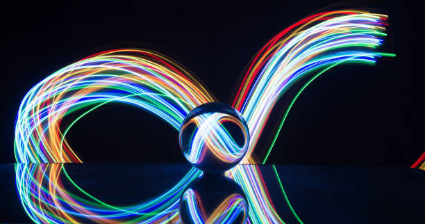 istock Light painting with crystal ball using led Christmas colorful lights and light reflection on glass with selective focus 1150779348