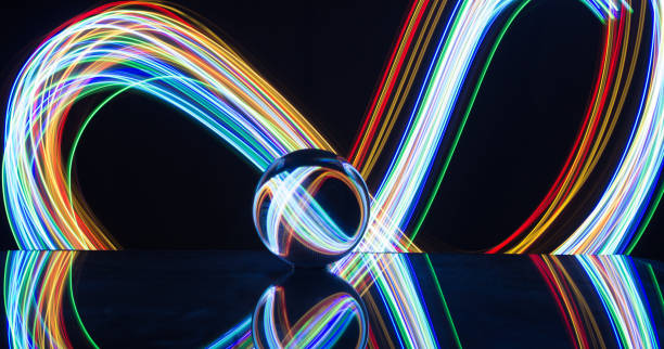 istock Light painting with crystal ball using led Christmas colorful lights and light reflection on glass with selective focus 1150779401