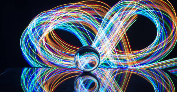 istock Light painting with crystal ball using led Christmas colorful lights and light reflection on glass with selective focus 1150779474