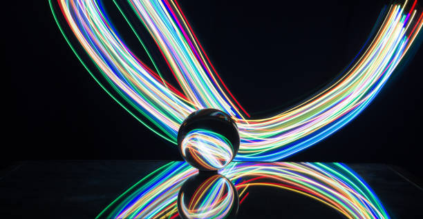 istock Light painting with crystal ball using led Christmas colorful lights and light reflection on glass with selective focus 1150779485