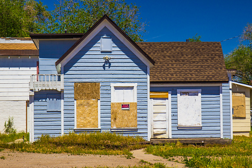 Abandoned House In Disrepair With Boarded Up Windows