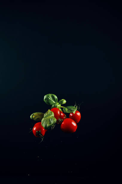 チェリートマトとバジルの食品爆発 - cherry tomato flash ストックフォトと画像