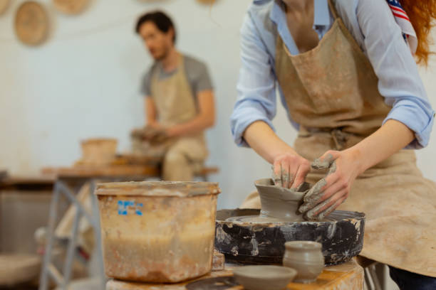istock Ginger curly girl in grey apron molding tall pot 1150786207