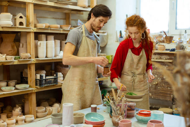 istock Bearded attentive guy mixing colors while his ginger woman 1150786211