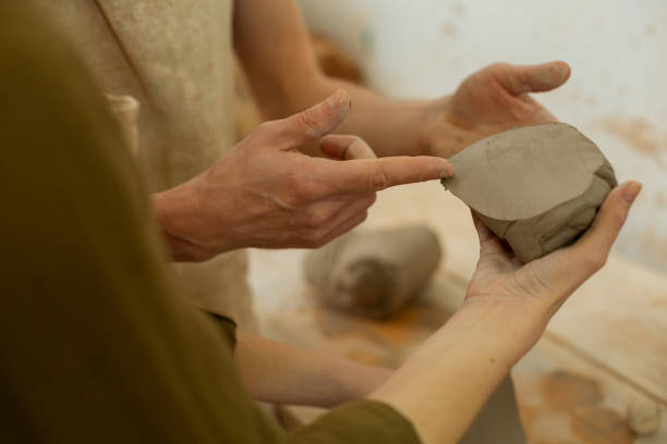istock Master pointing on cut piece of fresh clay and talking 1150786302