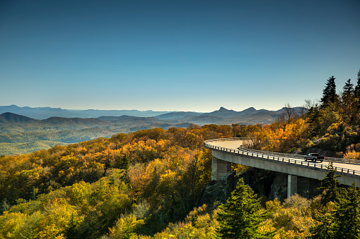Cars travel on the Linn Cove Viaduct highway road on the Grandfather Mountain along the Blue Ridge Parkway in autumn North Carolina USA