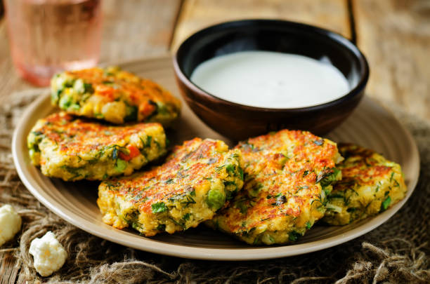 Cauliflower carrot green peas dill fritters with sour cream Cauliflower carrot green peas dill fritters. toning. selective focus pepper cake stock pictures, royalty-free photos & images