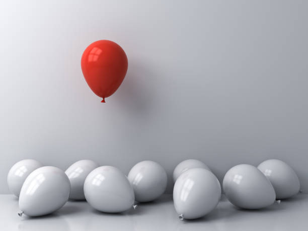 istock Stand out from the crowd and different concepts One red balloon floating above other white balloons on white wall background with window reflections and shadows 1150792084