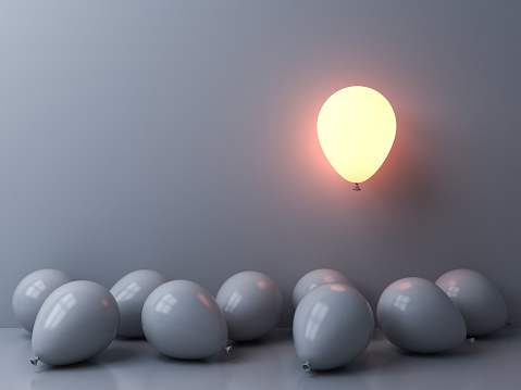 Stand out from the crowd and different concepts One light balloon glowing and floating above other white balloons on white wall background with window reflections and shadows 3D rendering
