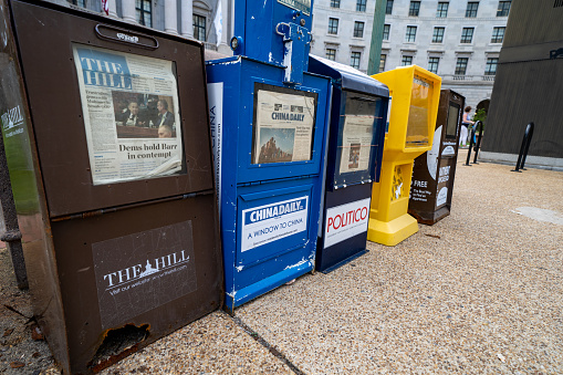 Washington DC - May 9, 2019: Newspaper vending machines along the sidewalks of downtown District of Columbia, for periodicals such as The Hill, Politico, and other news magazines