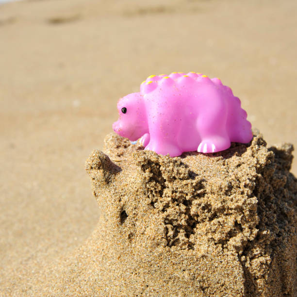 Dinosaur plastic toy on the beach
