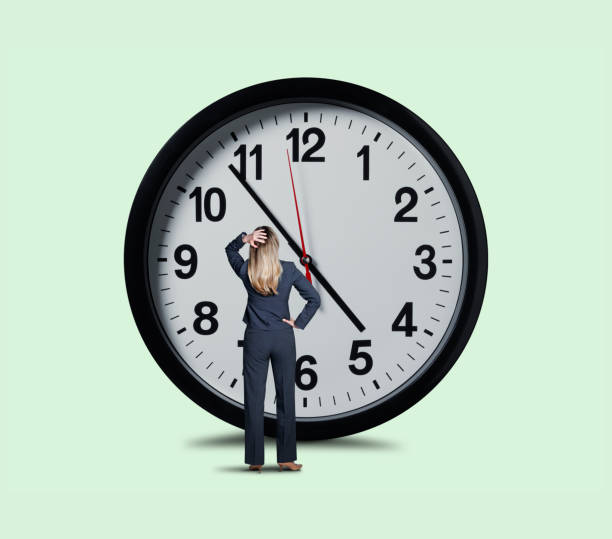istock Businesswoman Looking Up At Large Clock 1150796486