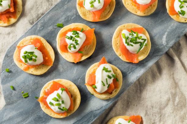 Homemade Smoked Salmon Cocktail Blinis Homemade Smoked Salmon Cocktail Blinis with Creme and Chives blini photos stock pictures, royalty-free photos & images