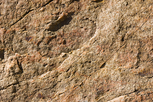 Background of granite. Texture of granite stone. Pattern of roughened surface. Texture of brown stone