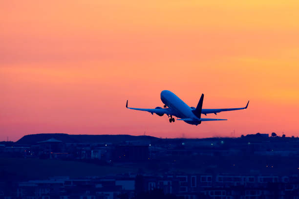 Passenger airplane taking off on sunset stock photo