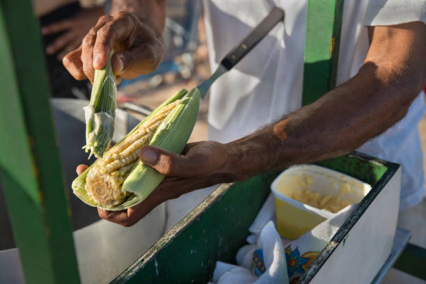 Man serving streed food - corn on a cob sweetcorn