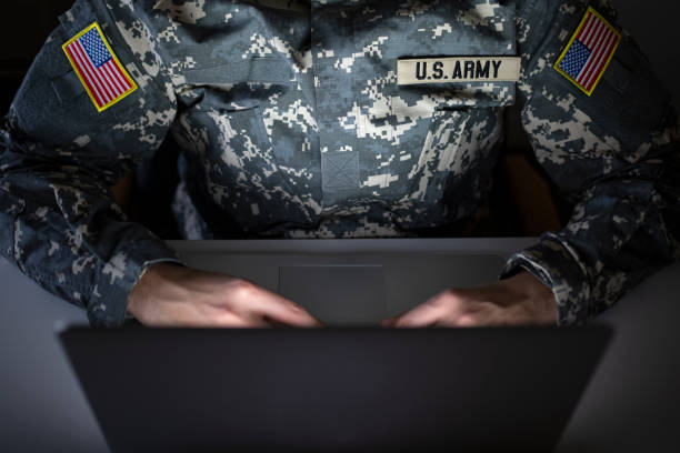 Shot of an unrecognizable American soldier in military uniform using computer in communication - intelligence center. Surveillance and border protection.