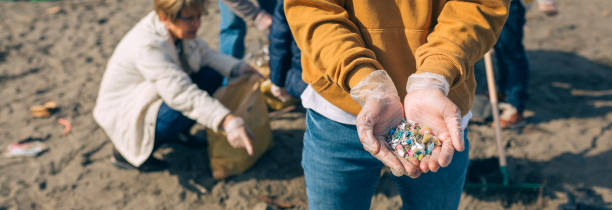 Hands with microplastics on the beach Detail of young man hands showing microplastics on the beach microplastic photos stock pictures, royalty-free photos & images