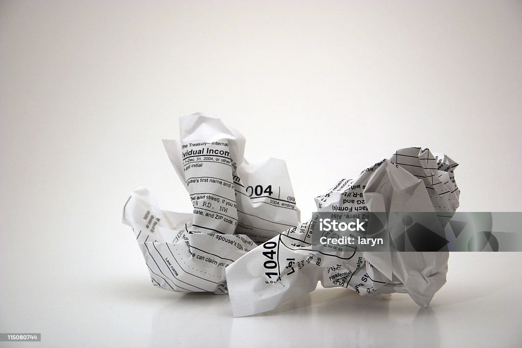 Tax time (frustration with taxes) Visual metaphor for the frustration of doing the annual tax time ritual...the 1040 tax form, crumpled in a ball over a white background.  Tax Stock Photo