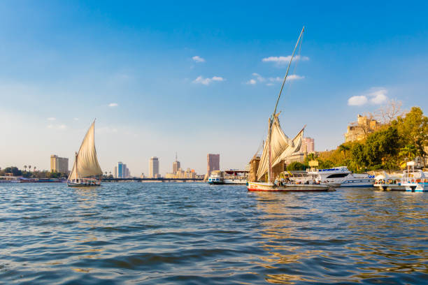 View of Cairo skyline from the boat on the river Nile. Boats with tourists look around at the streets of the city of Cairo on a nice day.