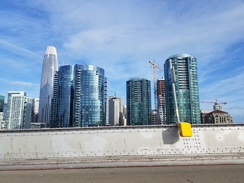 San Francisco, California, United States - May 17, 2019:  Urban skyline of San Francisco, California, including Salesforce Tower, viewed on a sunny day from in front of a metal wall, May 17, 2019.