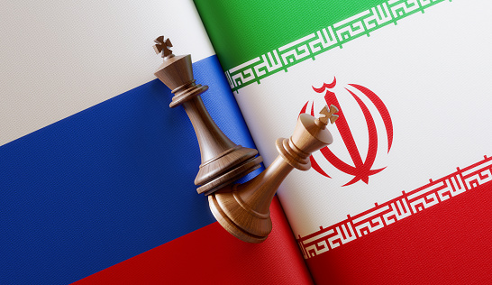 Russian and Iranian flag pair with king chess pieces. Horizontal composition with copy space and selective focus.