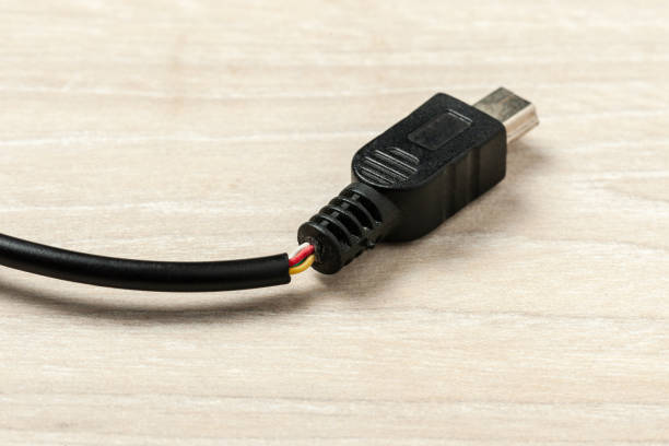 istock Broken black usb cable on a wooden background. old wire with dust. 1150829137