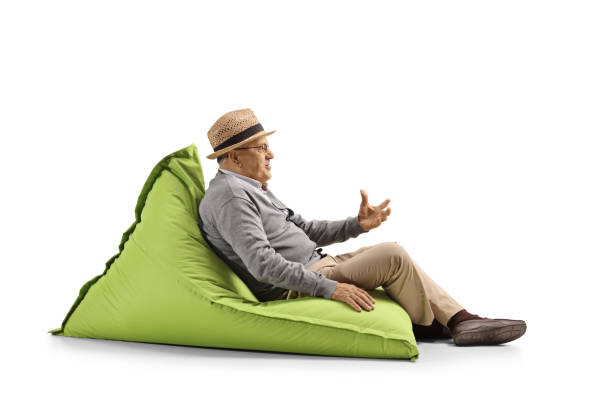 istock Senior man sitting on a bean-bag and gesturing with hand 1150831517