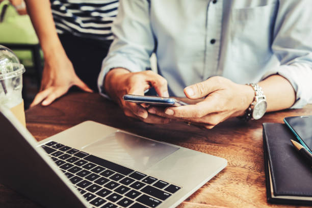 istock Two people using mobile while meeting in coffee shop for SMEs owner job 1150838911