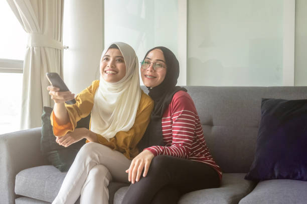 istock Two muslim lady watching TV shows together 1150844174