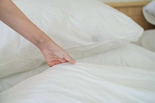 istock hand holding white bed sheet in room 1150845963